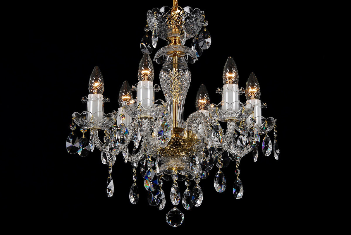Lustre en cristal à six bras, vue de face sur fond noir, allumé.