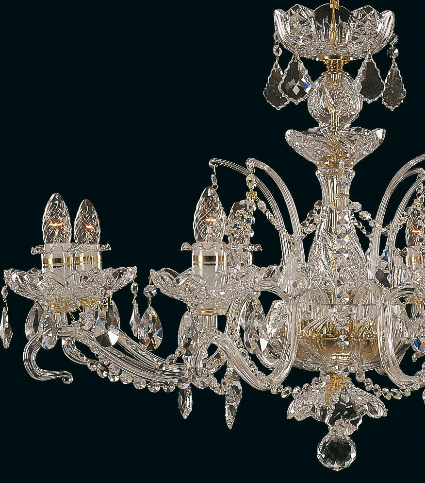 Gros plan sur les bras recourbés, coupelles fleuries et pendeloques de cristal du lustre