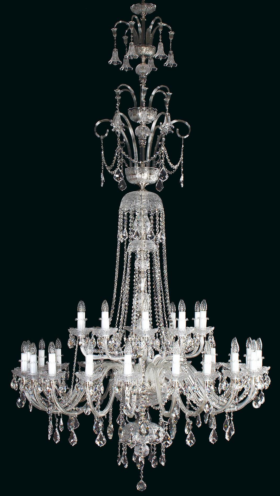 Lustre en cristal complet sur fond noir, avec bras, ampoules et pendeloques.