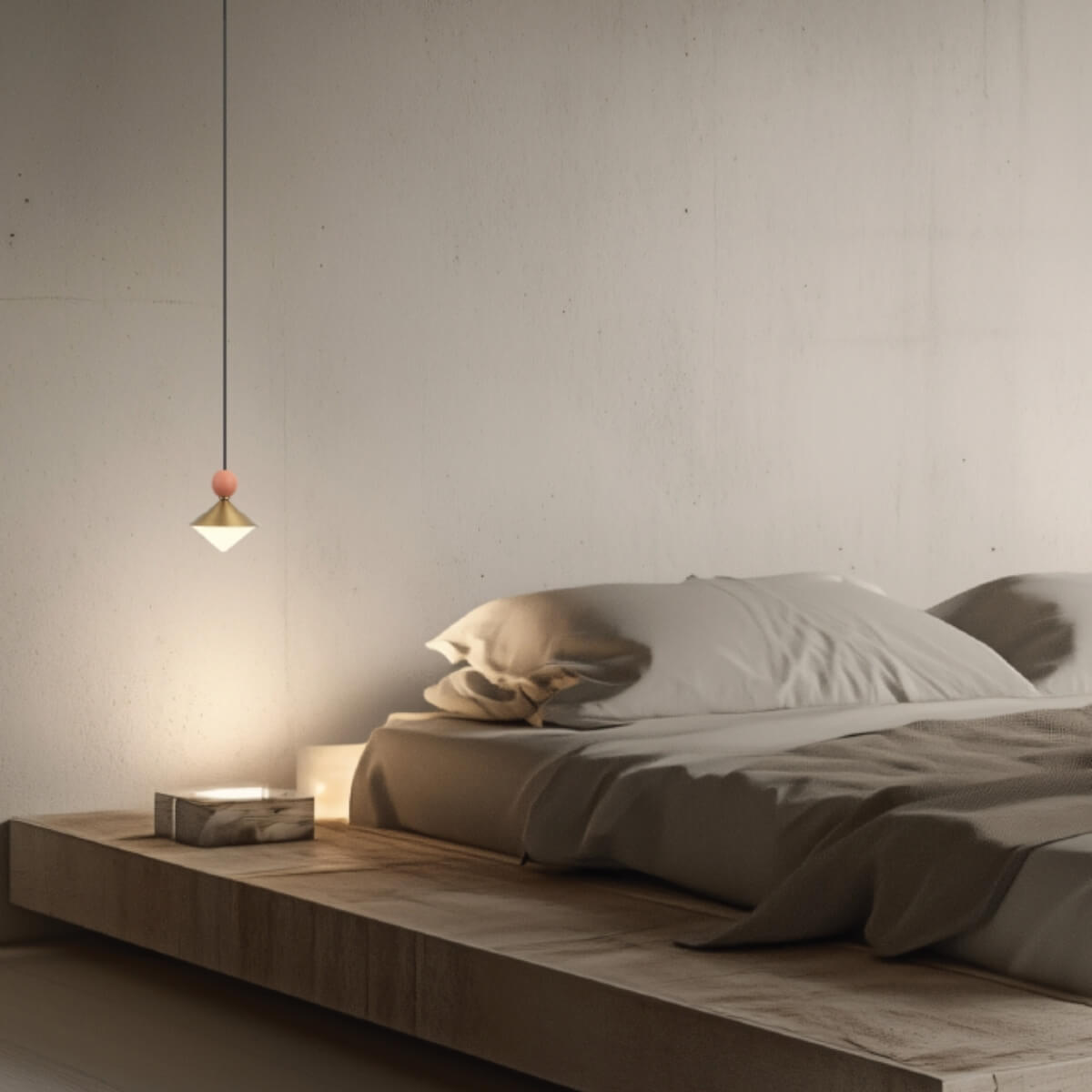 Vue rapprochée du luminaire suspendu, sphère terracotta et cône laiton éclairant la literie