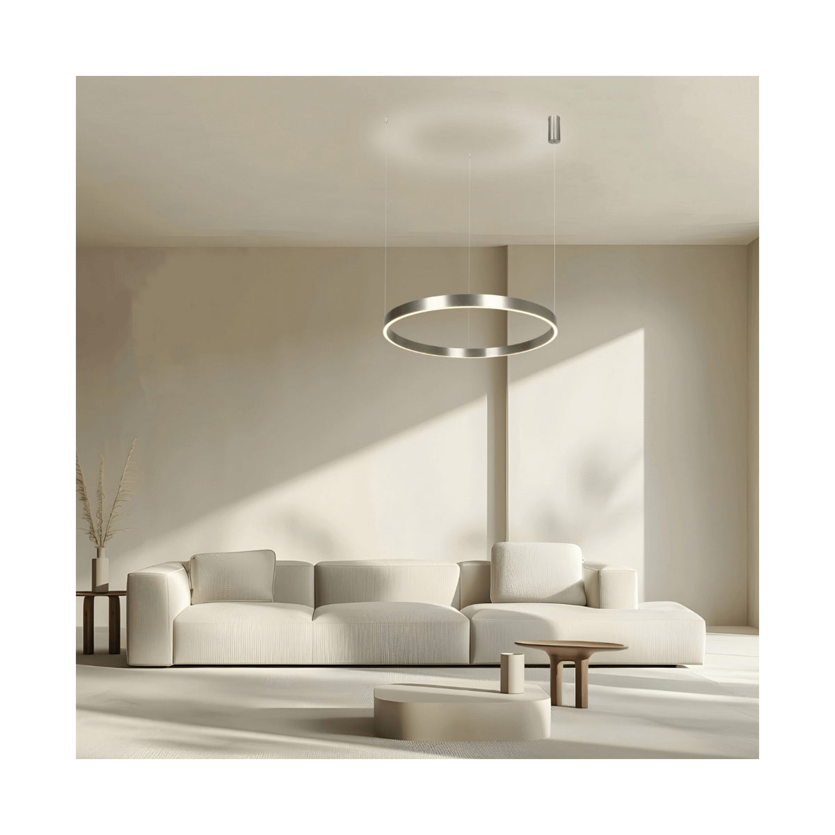 Ambiance de séjour épuré, suspension circulaire allumée diffusant une lumière douce