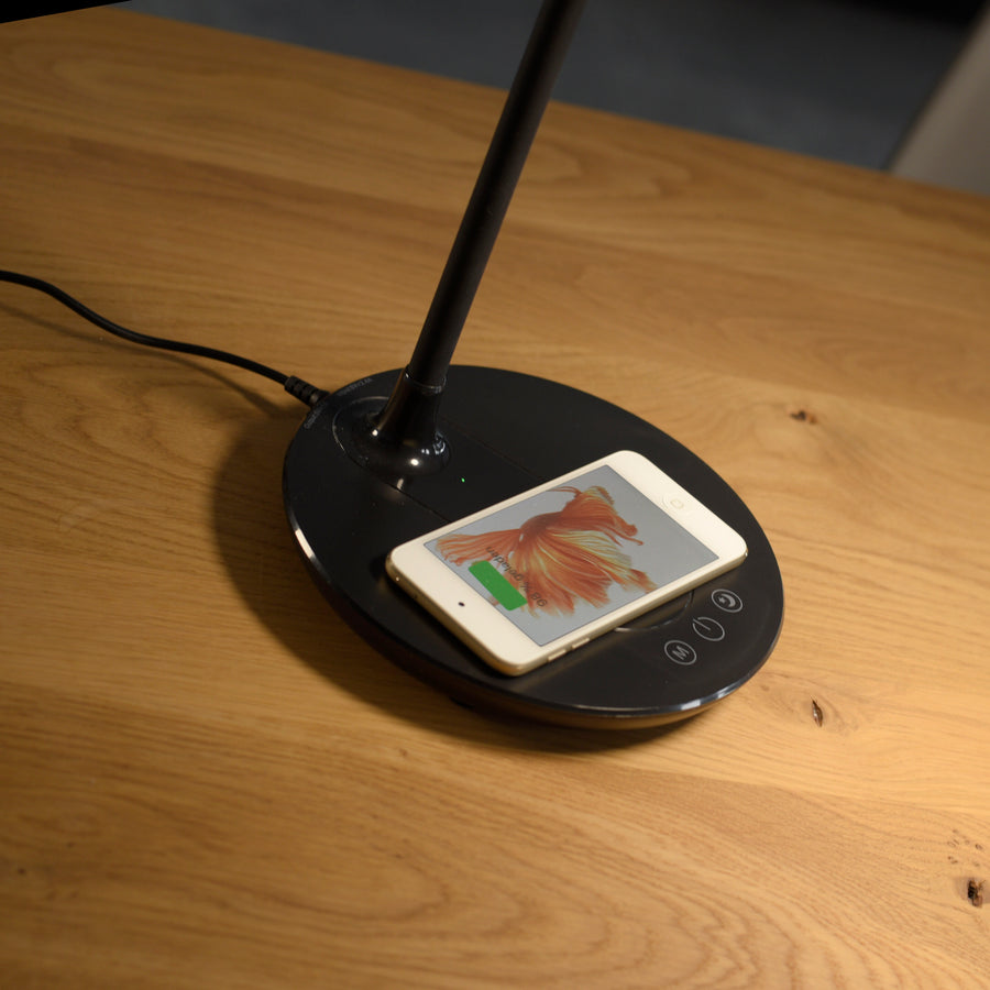 Base ronde avec smartphone en charge par induction sur table en bois