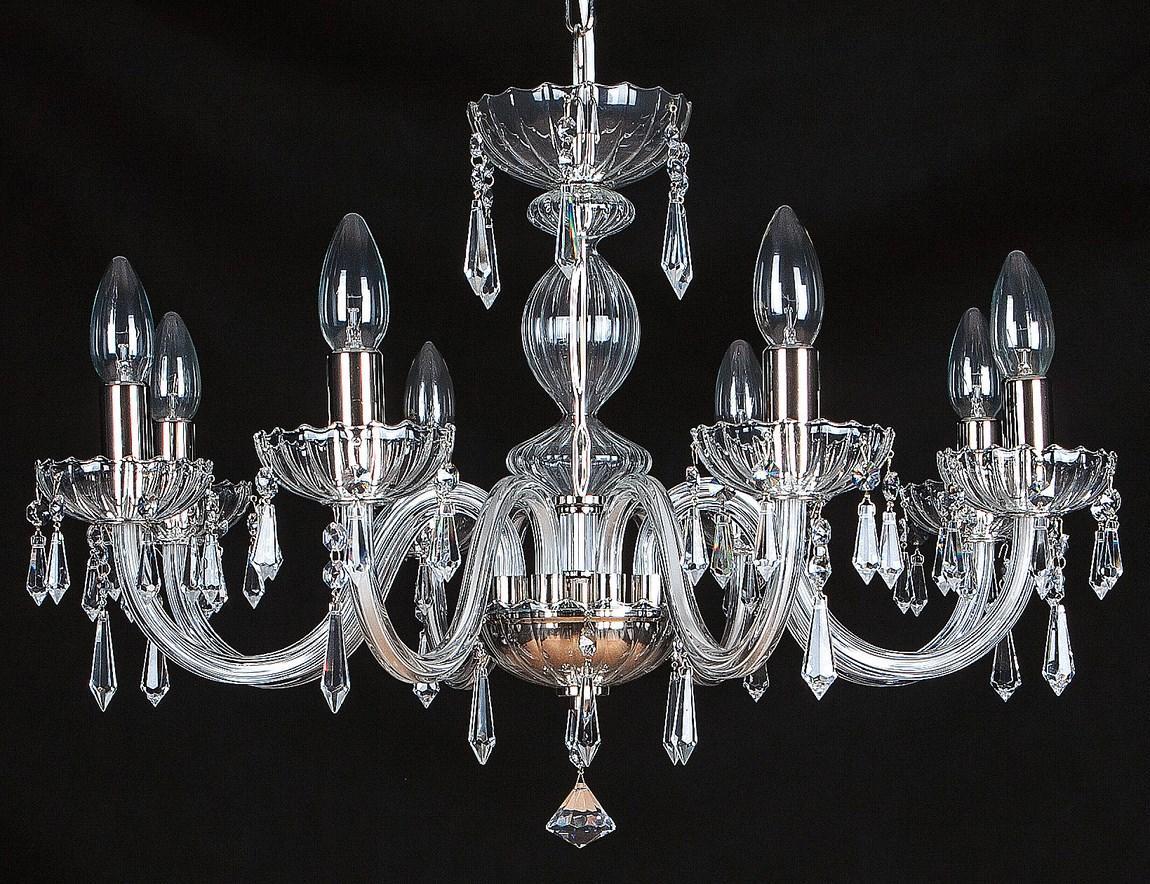 Lustre en cristal transparent photographié de face sur fond noir, six bras lumineux visibles