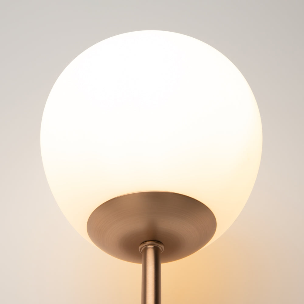 Gros plan sur le globe opalin et la coupelle dorée du luminaire