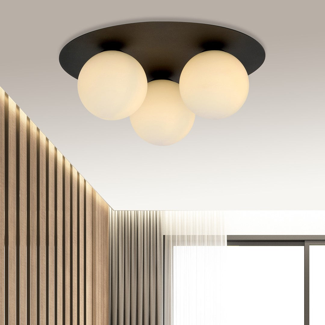 Mise en ambiance dans un salon moderne, plafonnier allumé au-dessus de murs lambrissés.