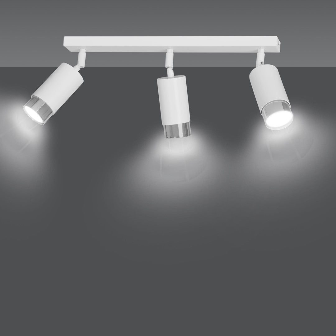 Luminaire allumé sur fond gris, trois faisceaux lumineux blancs projetés vers le bas