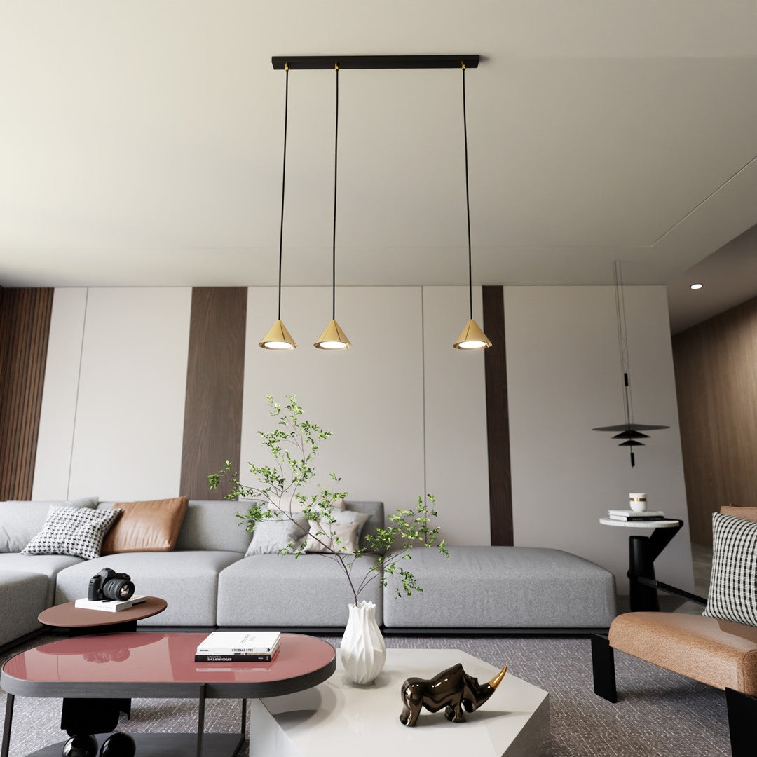 Scène d'intérieur : la suspension à trois cônes dorés surplombe un salon contemporain gris et bois.