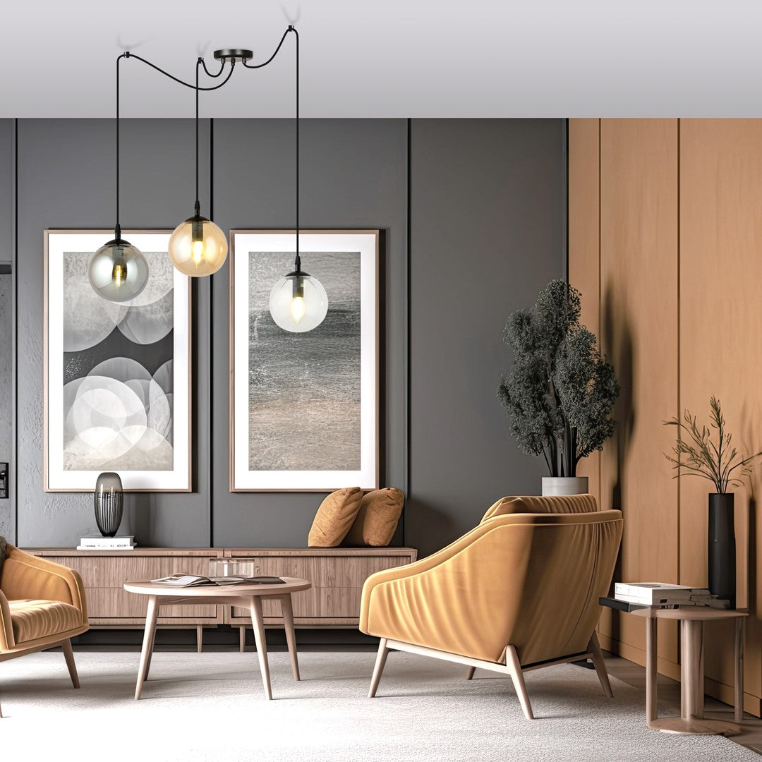 Mise en ambiance dans un salon gris et bois, suspension allumée au-dessus des fauteuils