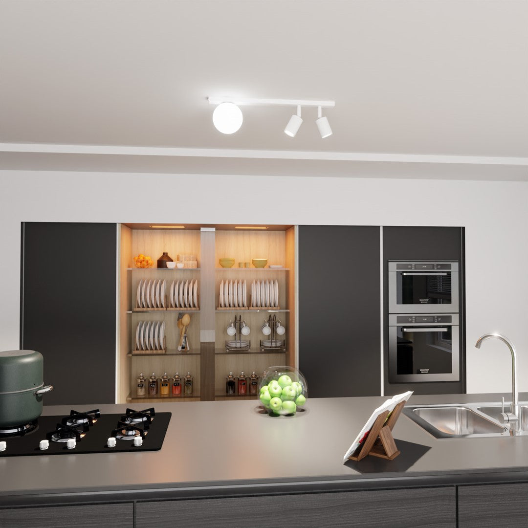 Vue large d'une cuisine moderne éclairée par le plafonnier blanc fixé au plafond