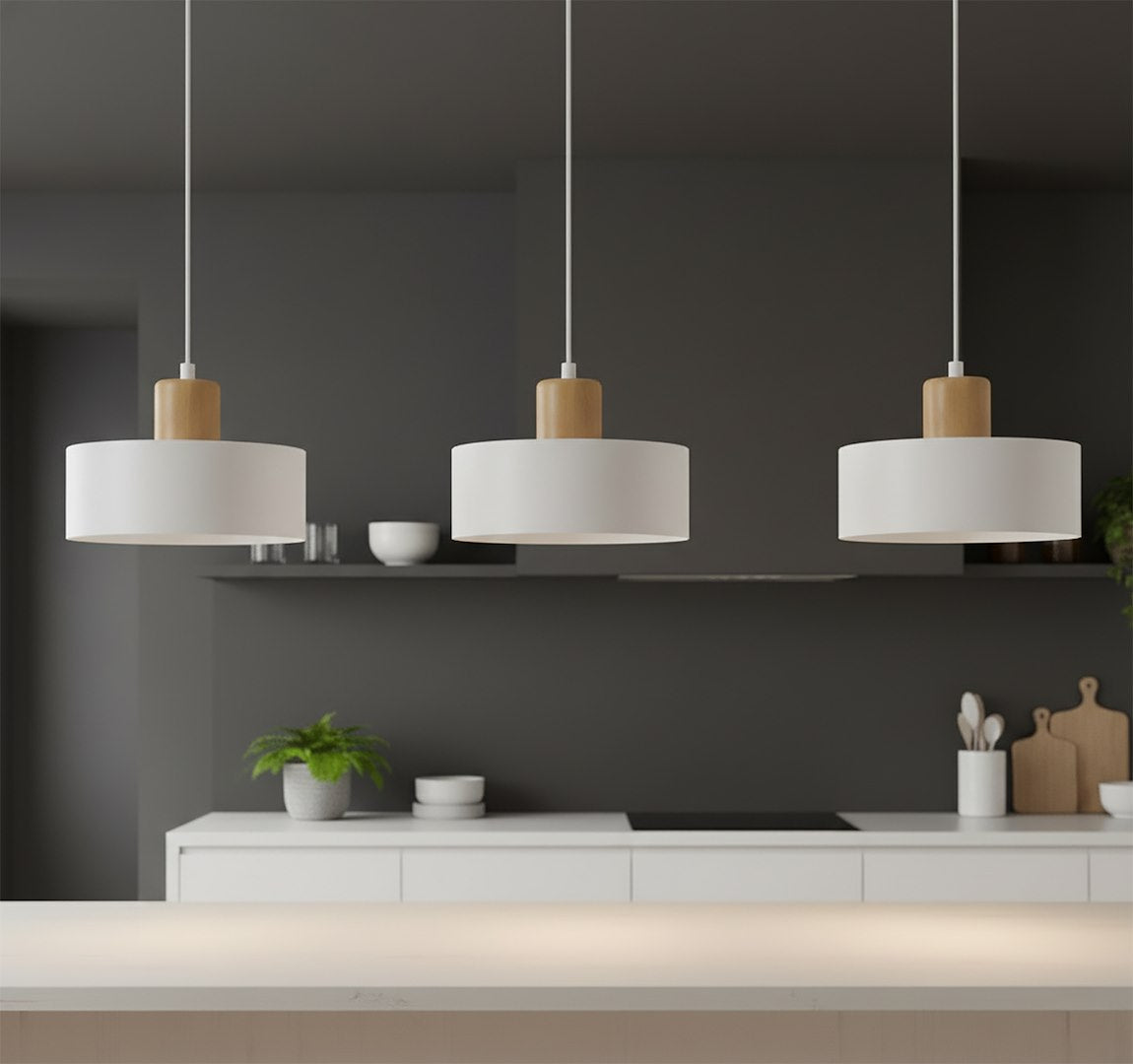 Trois luminaires suspendus dans une cuisine sombre aux murs gris anthracite