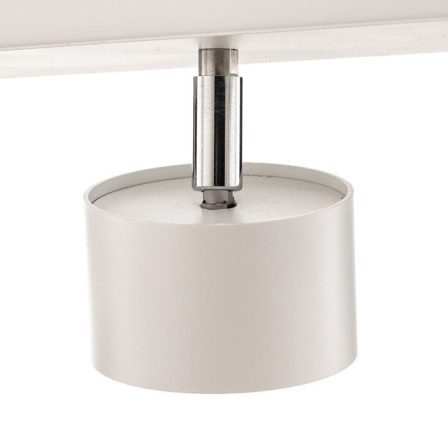 Détail du raccord chromé et du cylindre blanc d’un spot orientable.