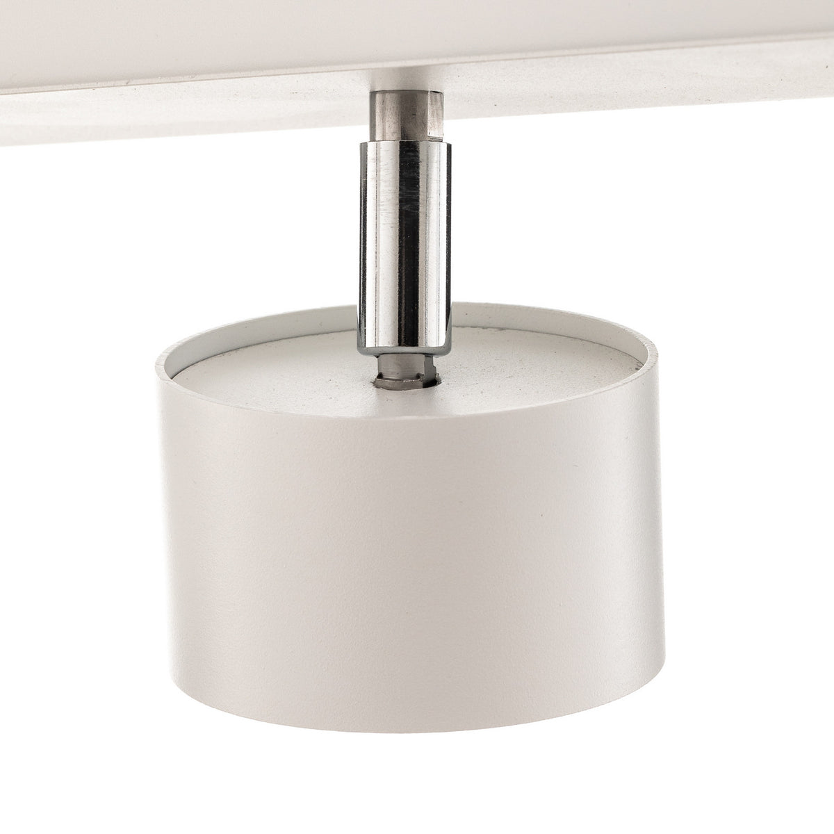 Détail du raccord chromé et du cylindre blanc d’un spot orientable.
