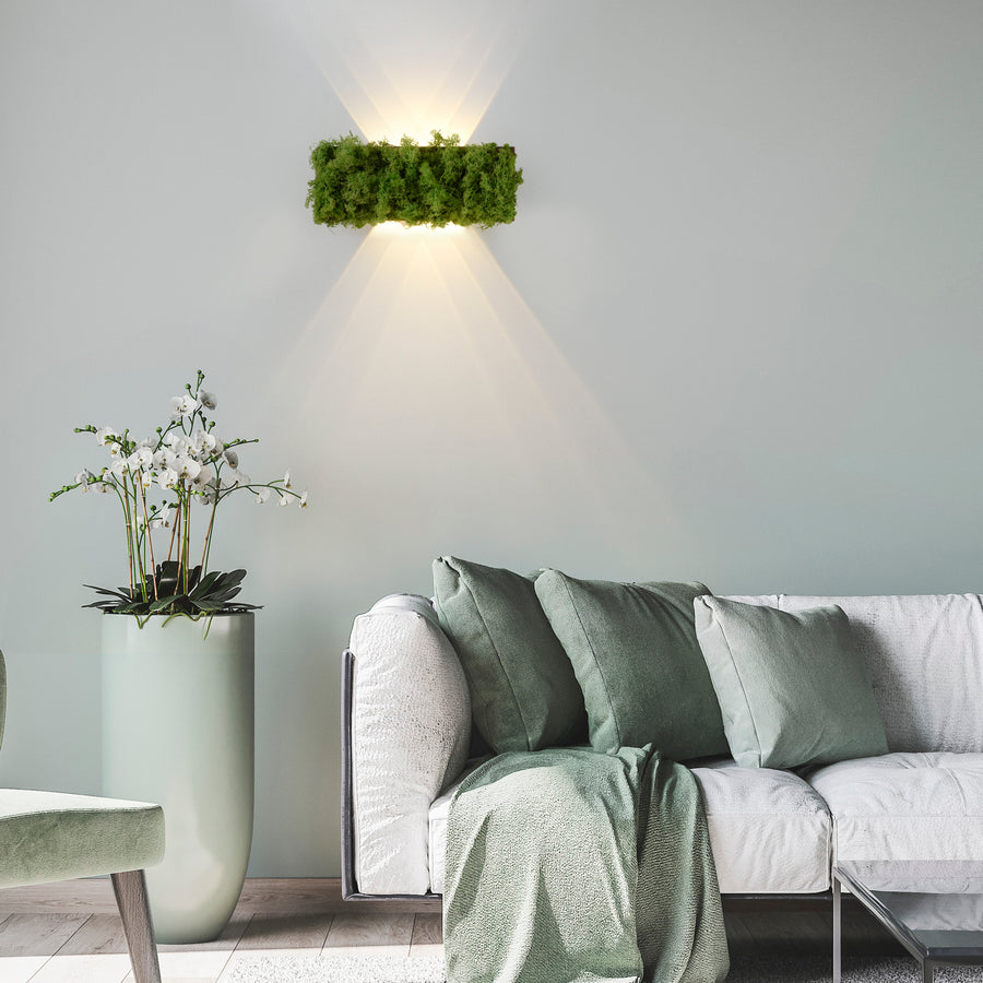 Luminaire mural en mousse allumé au-dessus d'un canapé, éclairant le mur vers le haut et bas.