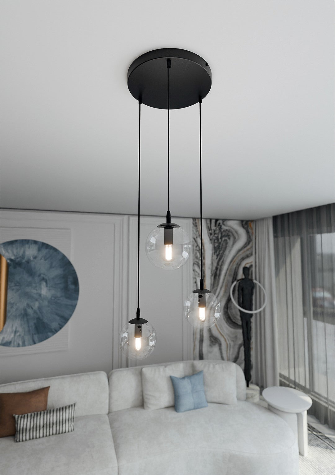 Vue en contre-plongée de la suspension allumée dans un salon, canapé et rideaux.