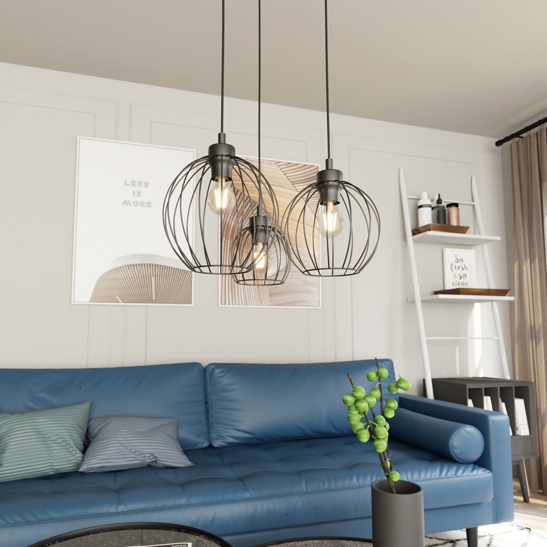 Gros plan sur les trois cages métalliques noires, ampoules allumées, intérieur salon.