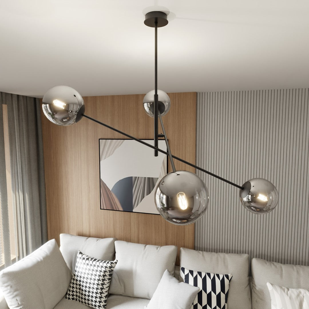 Gros plan des quatre globes en verre fumé, suspension fixée au plafond devant un mur bois.