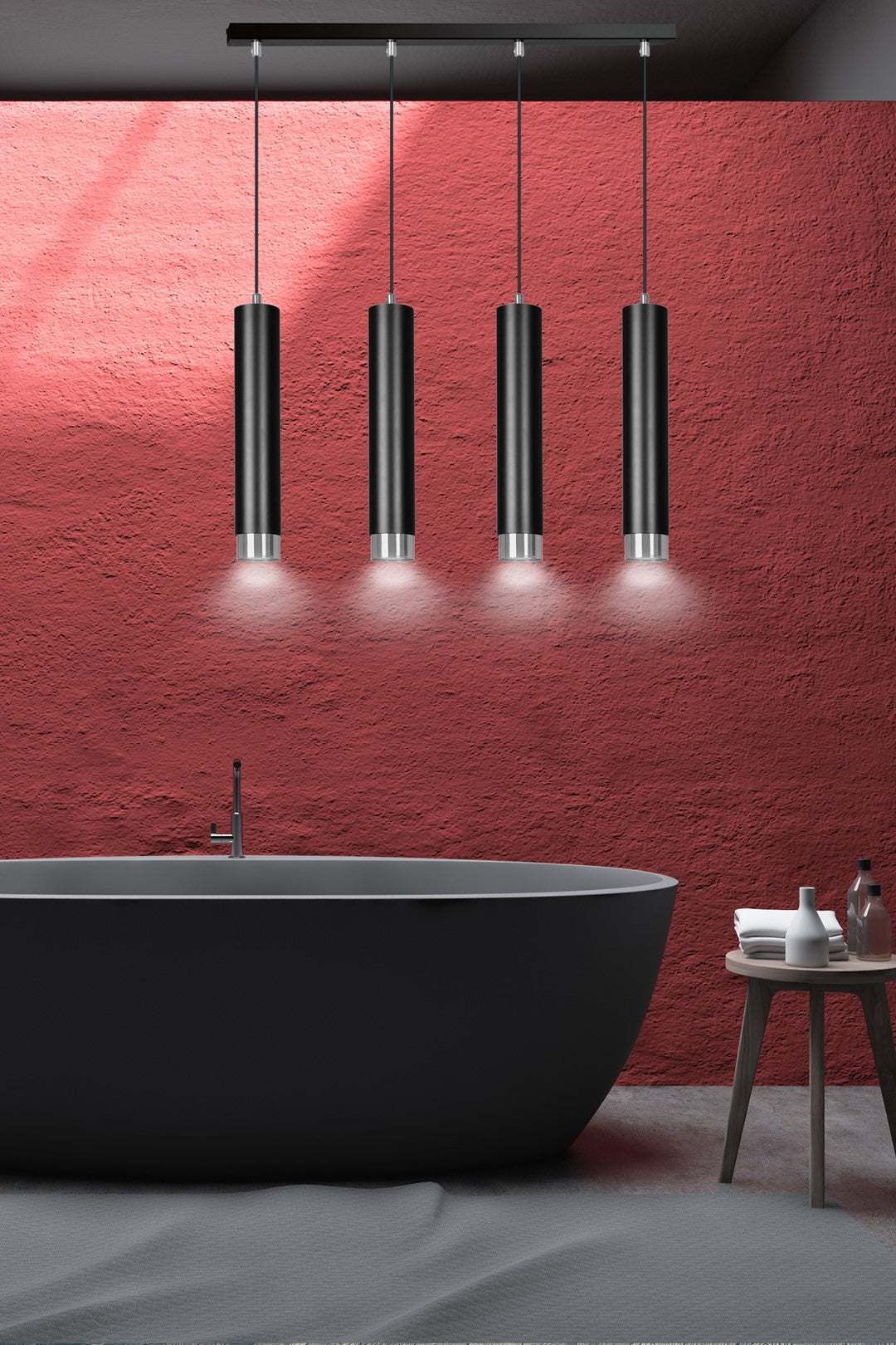 Ambiance salle de bain : suspension noire et chromée éclairant au-dessus d'une baignoire devant un mur rouge.