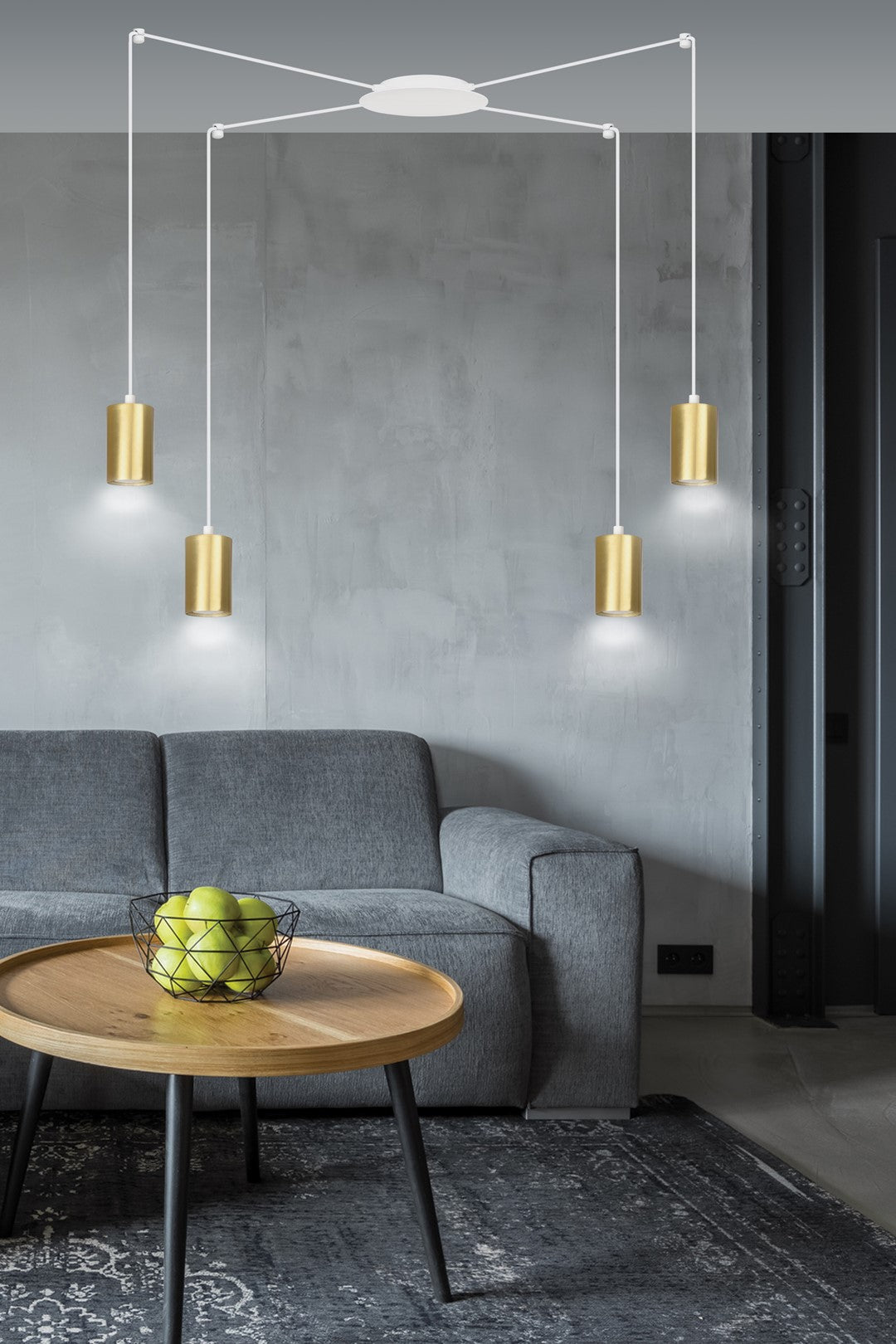 Mise en ambiance salon gris, suspension dorée au-dessus d'une table basse bois.