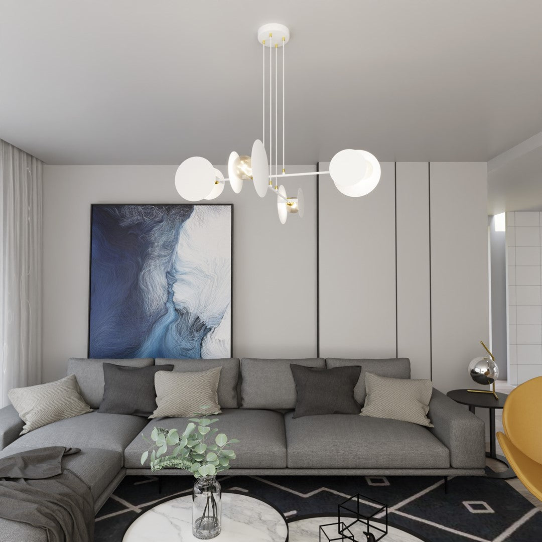 Vue frontale dans le salon, suspension blanche et coussins gris devant toile abstraite.
