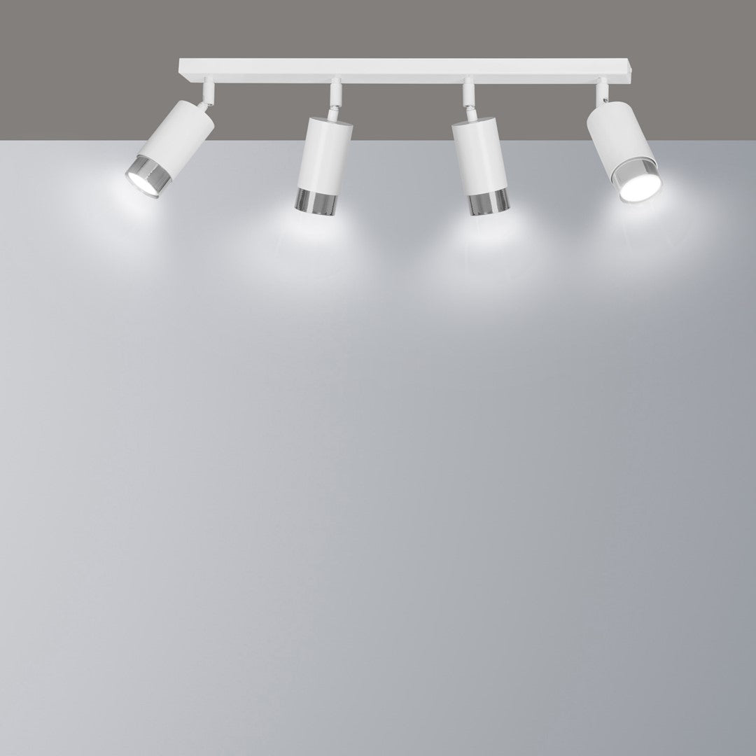 Plafonnier blanc fixé au plafond, quatre spots inclinés éclairant un mur gris de halos