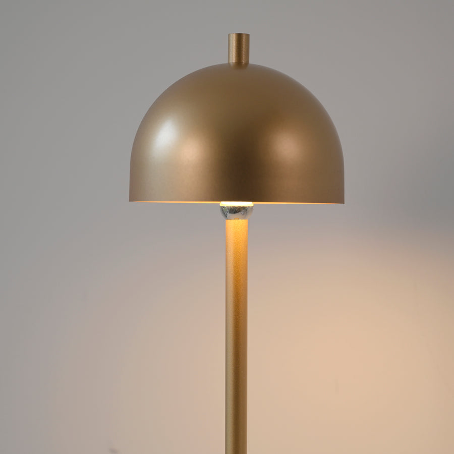 Détail rapproché de l’abat-jour doré et de la lumière allumée