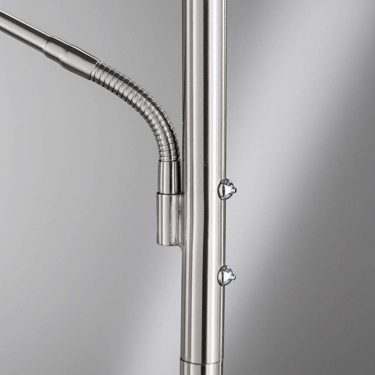 Gros plan sur le bras flexible et les vis de fixation du lampadaire.