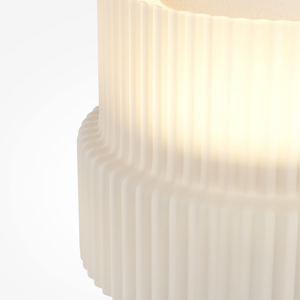 Gros plan sur la texture plissée et la lumière chaude traversant l'abat-jour