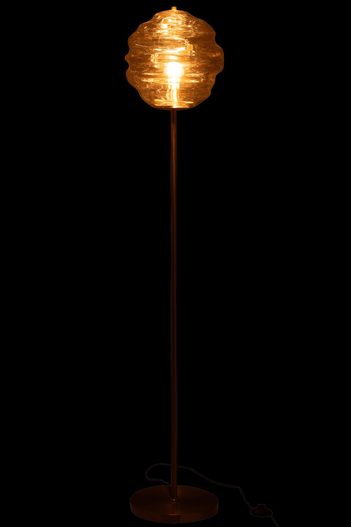 Lampadaire allumé sur fond noir, halo ambré traversant le verre soufflé
