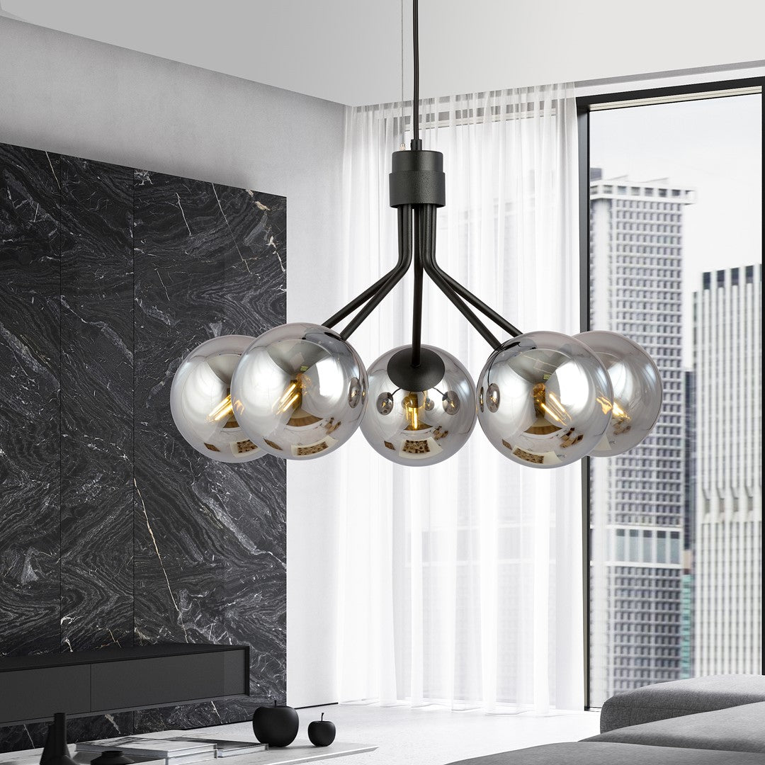 Mise en ambiance dans un salon moderne, suspension allumée devant une baie vitrée.
