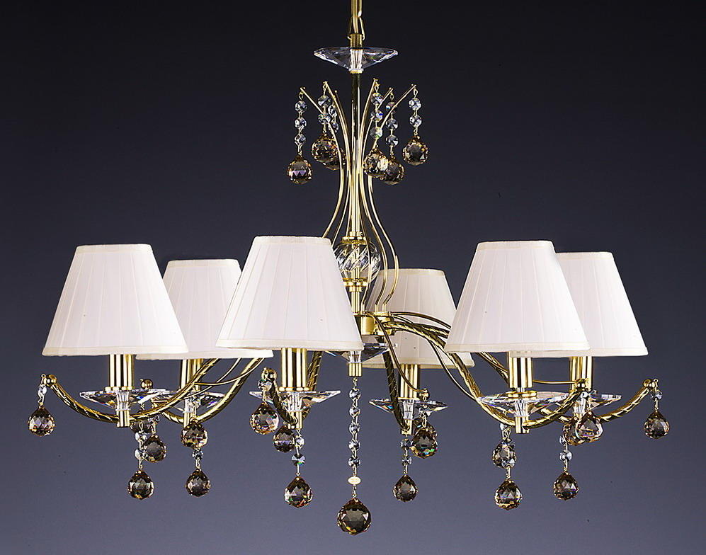 Lustre doré à six bras vu de face, pampilles de cristal et abat-jours blancs