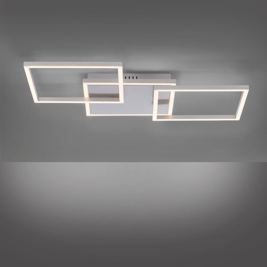 Plafonnier allumé fixé au plafond, halos de lumière blanche diffusés sur fond gris