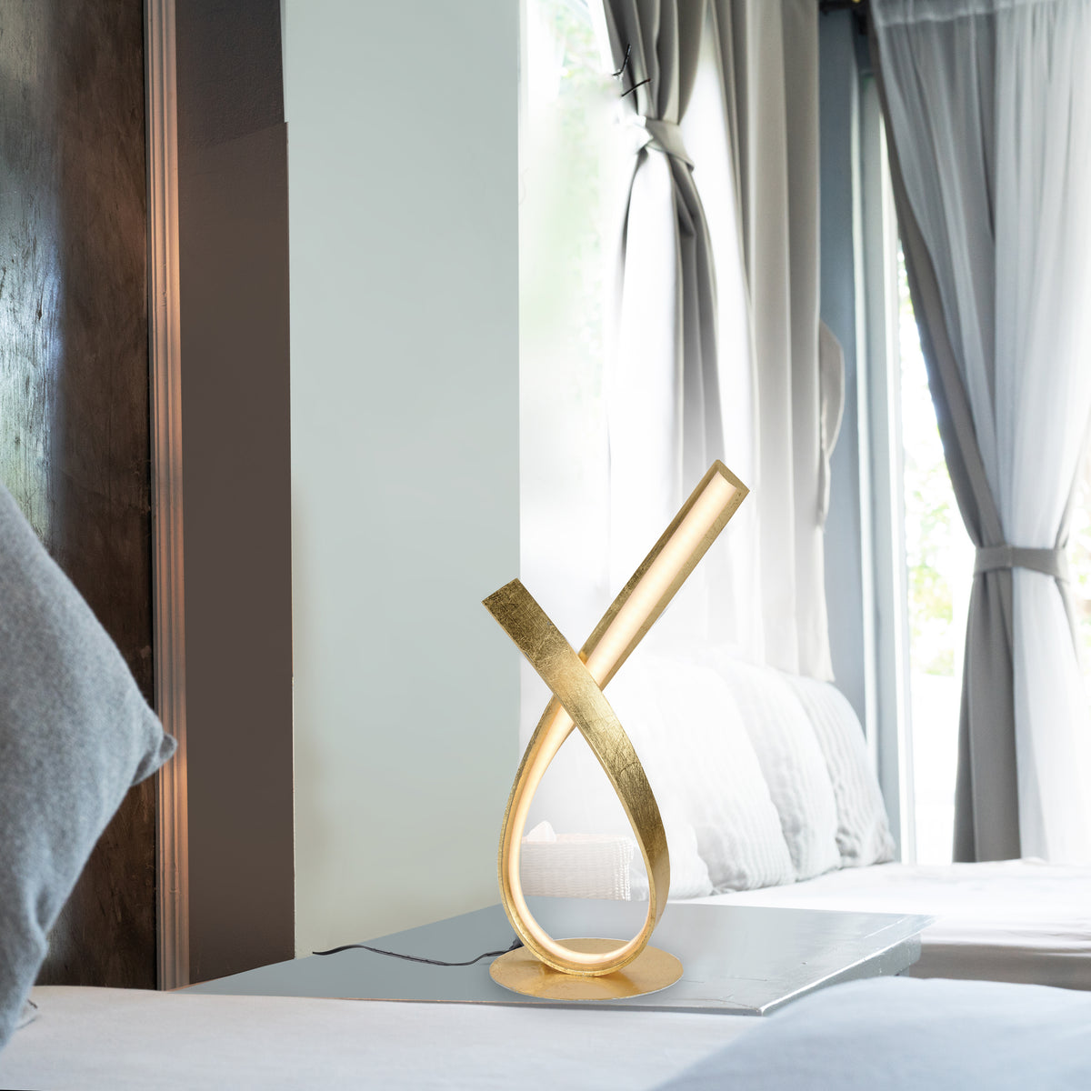 Mise en ambiance sur une table de chevet, près d'un lit et de rideaux