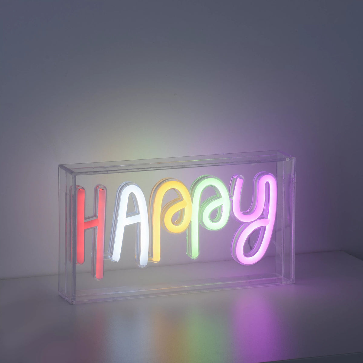 Luminaire allumé dans la pénombre, diffusant une lumière multicolore sur la surface.