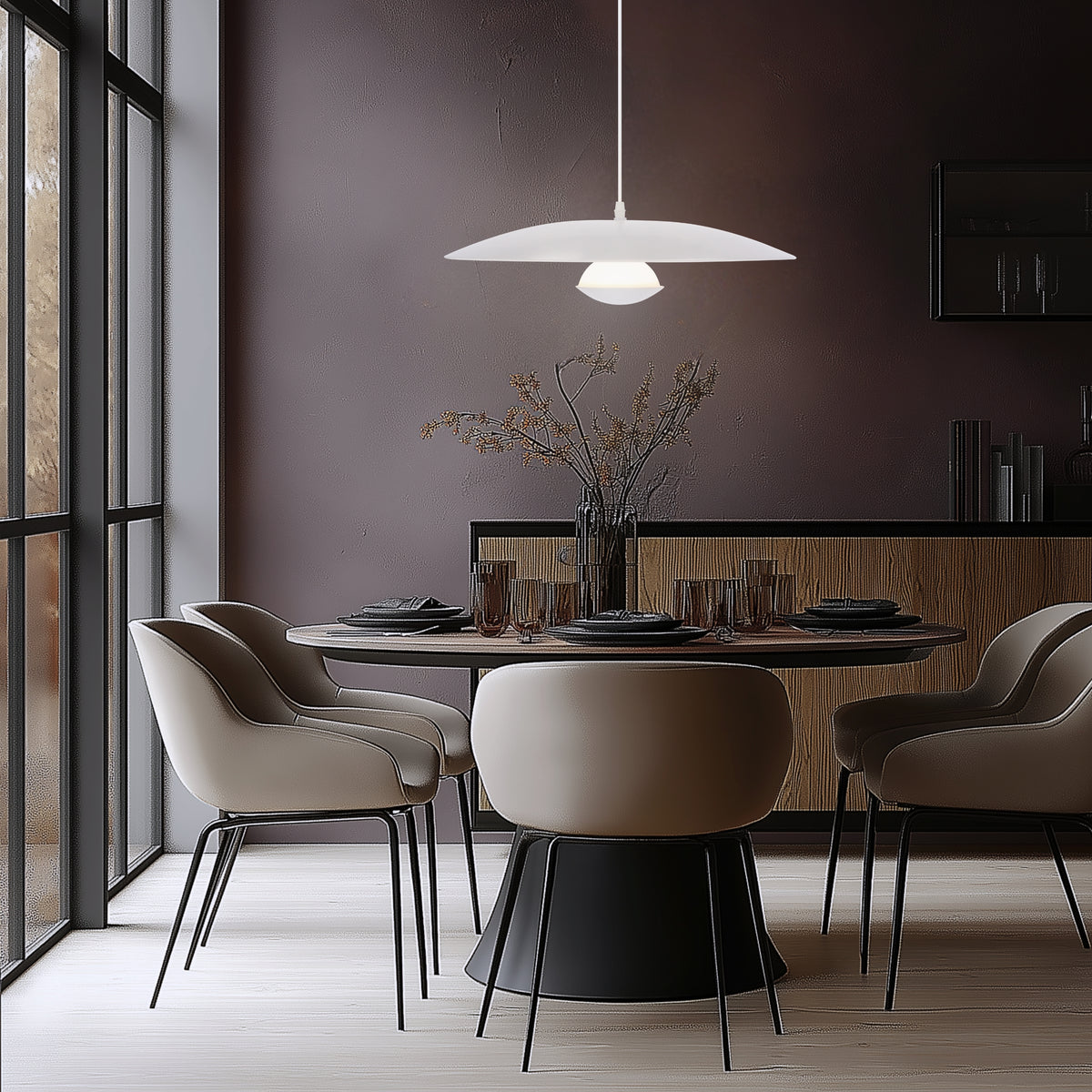 Scène d'intérieur contemporain, suspension allumée au-dessus d'une table dressée avec chaises beiges.