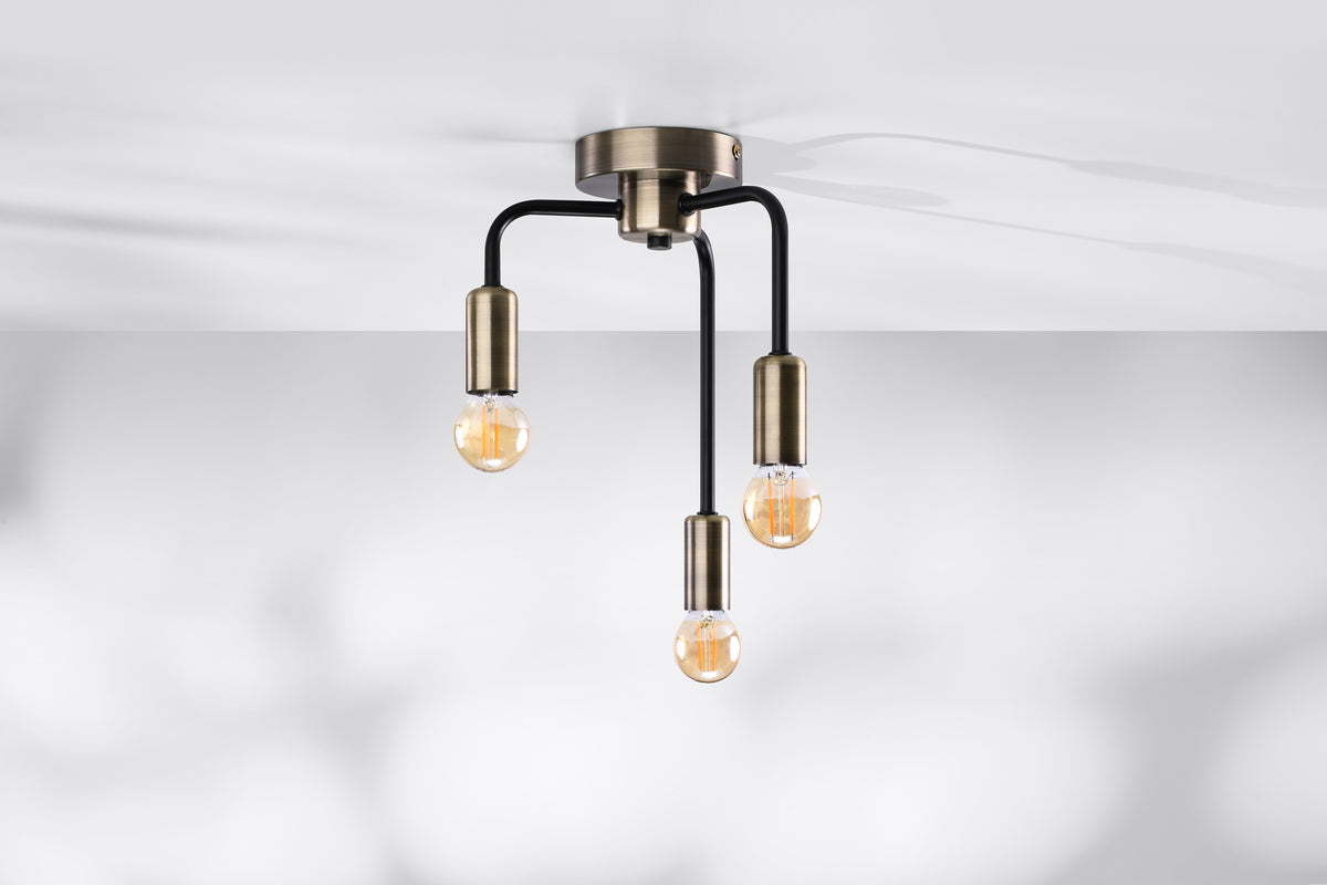 Luminaire installé au plafond blanc, ampoules allumées diffusant une lumière chaude