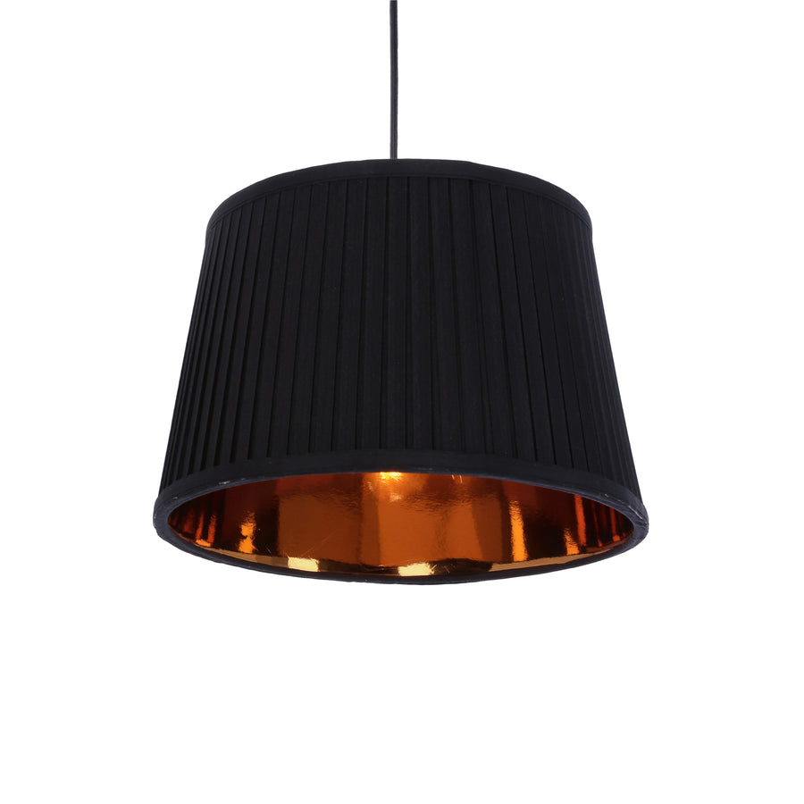 Gros plan sur un abat-jour noir plissé, intérieur doré réfléchissant la lumière.