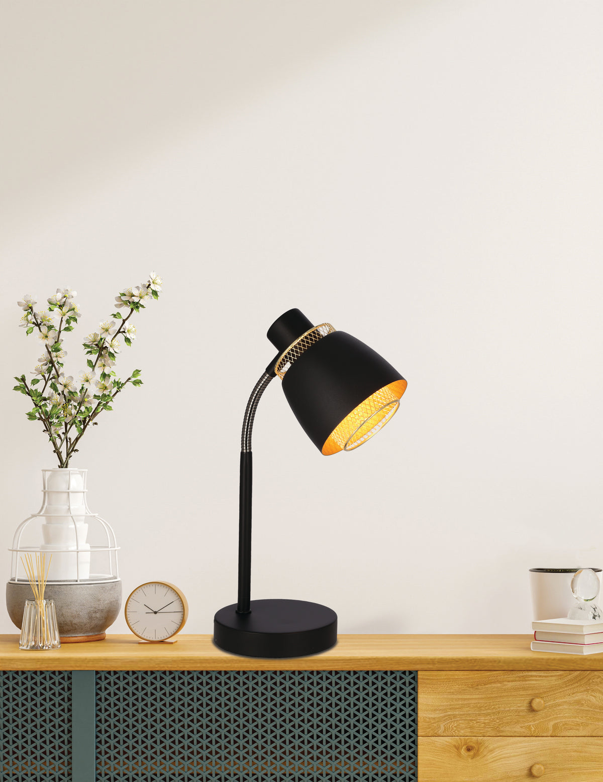 Mise en ambiance sur un meuble en bois, lampe allumée près d'un vase fleuri