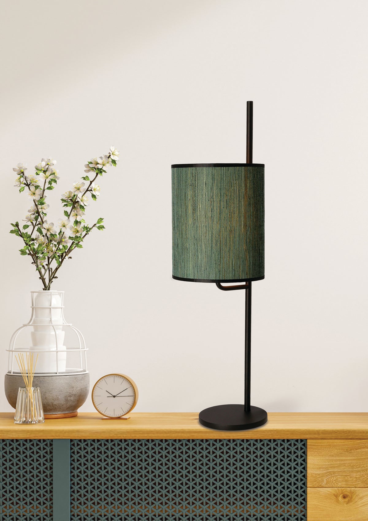 Mise en ambiance de la lampe posée sur un buffet en bois avec vase fleuri