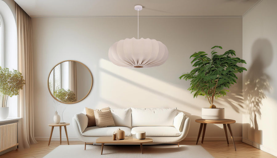 Suspension beige installée dans un salon contemporain, près d'un miroir rond.