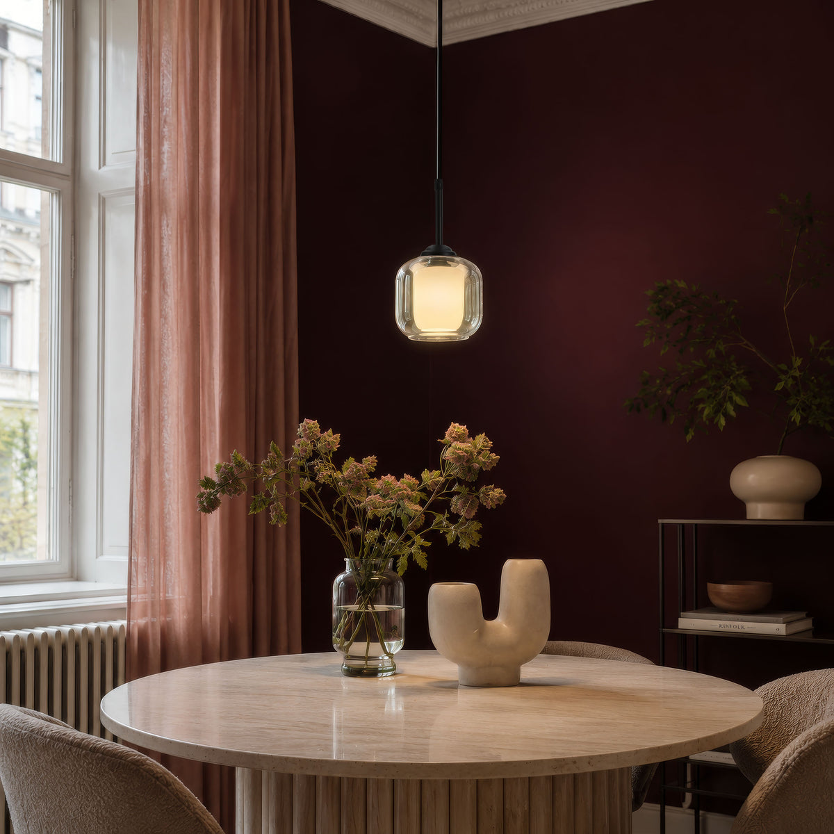 Mise en ambiance au-dessus d'une table ronde, luminaire allumé dans un intérieur sombre