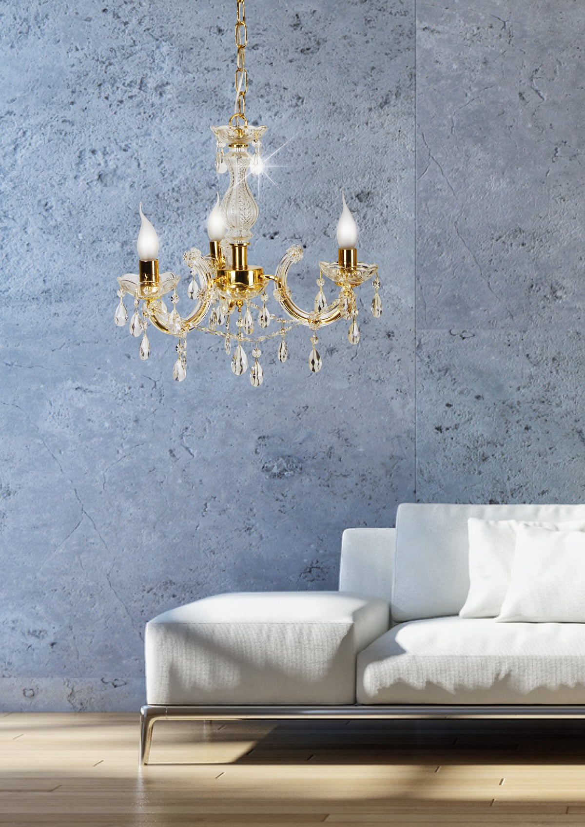 Lustre doré suspendu devant un mur bleu texturé, au-dessus d'un canapé blanc.