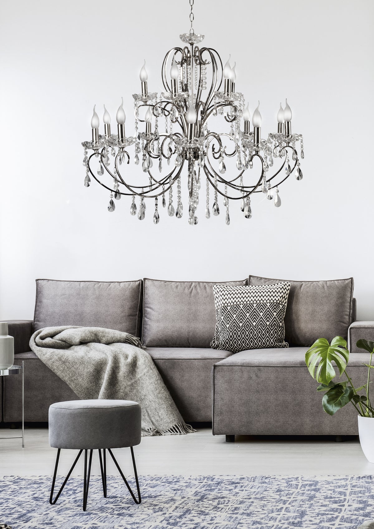 Suspension installée au-dessus d'un canapé gris, mise en ambiance dans un salon moderne