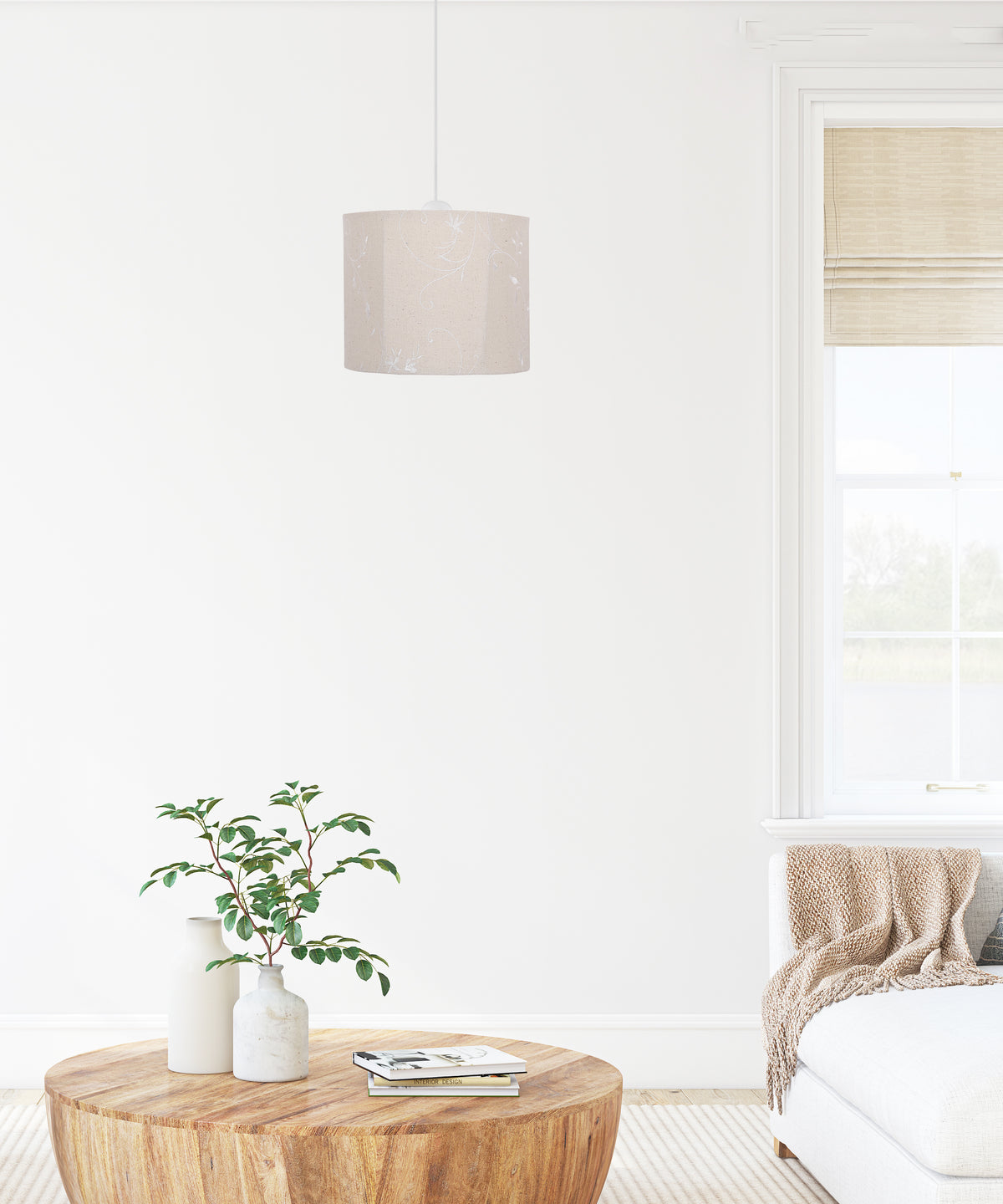 Suspension beige installée dans un salon blanc, au-dessus d'une table ronde en bois