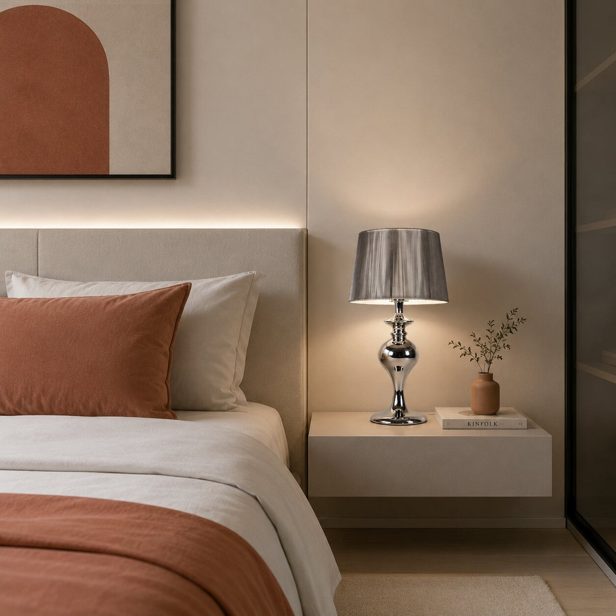 Scène de chambre montrant la lampe allumée près du lit et d'un vase.