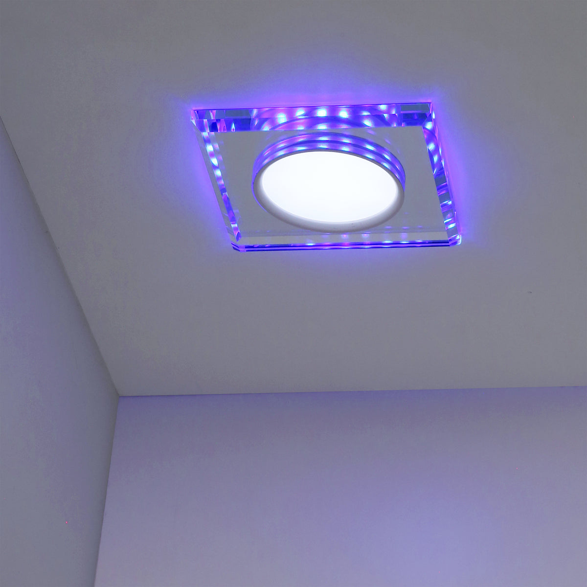 Spot encastré au plafond, halo bleu et violet dans la pièce