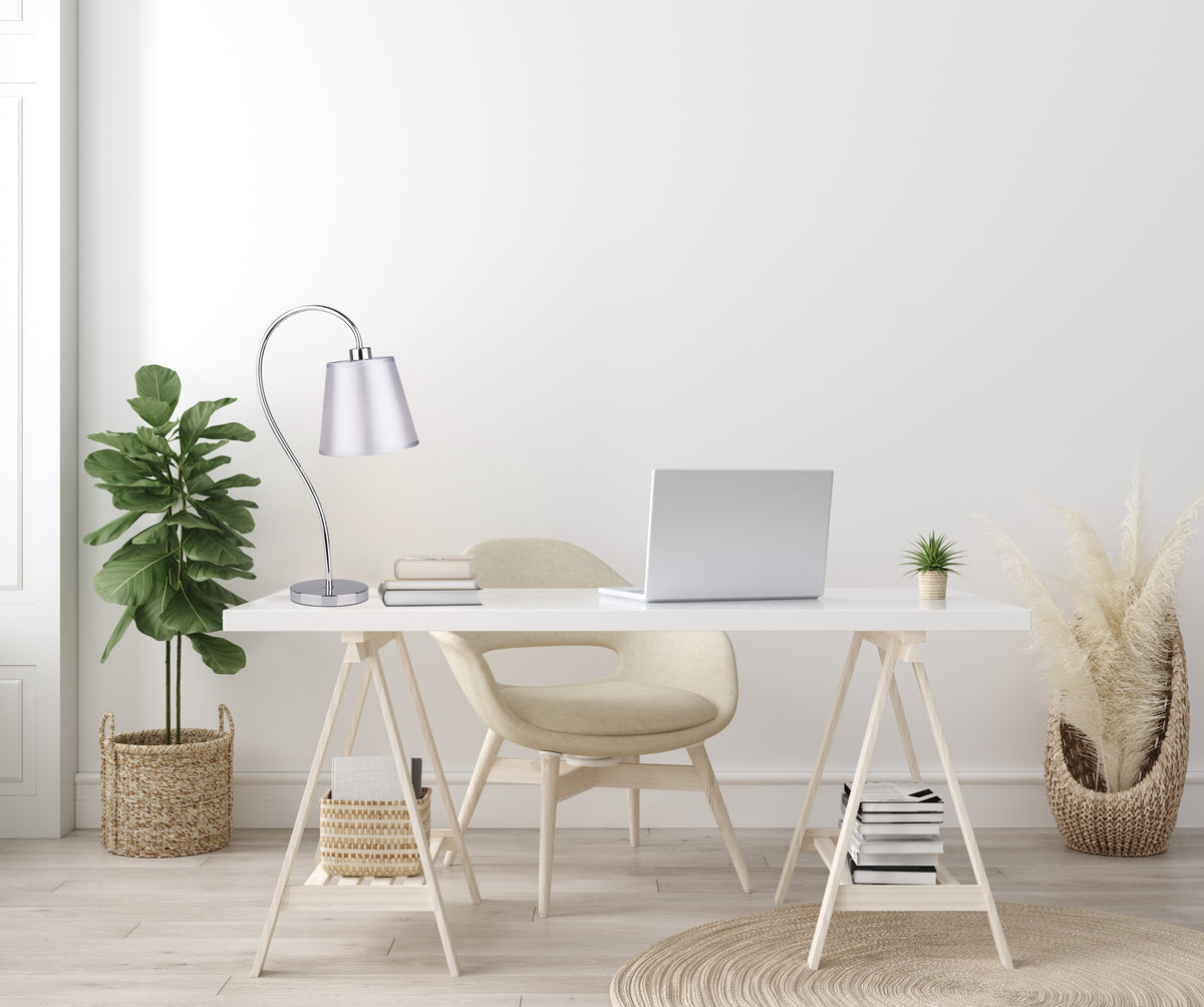 Mise en ambiance bureau clair, lampe posée sur table devant mur blanc.
