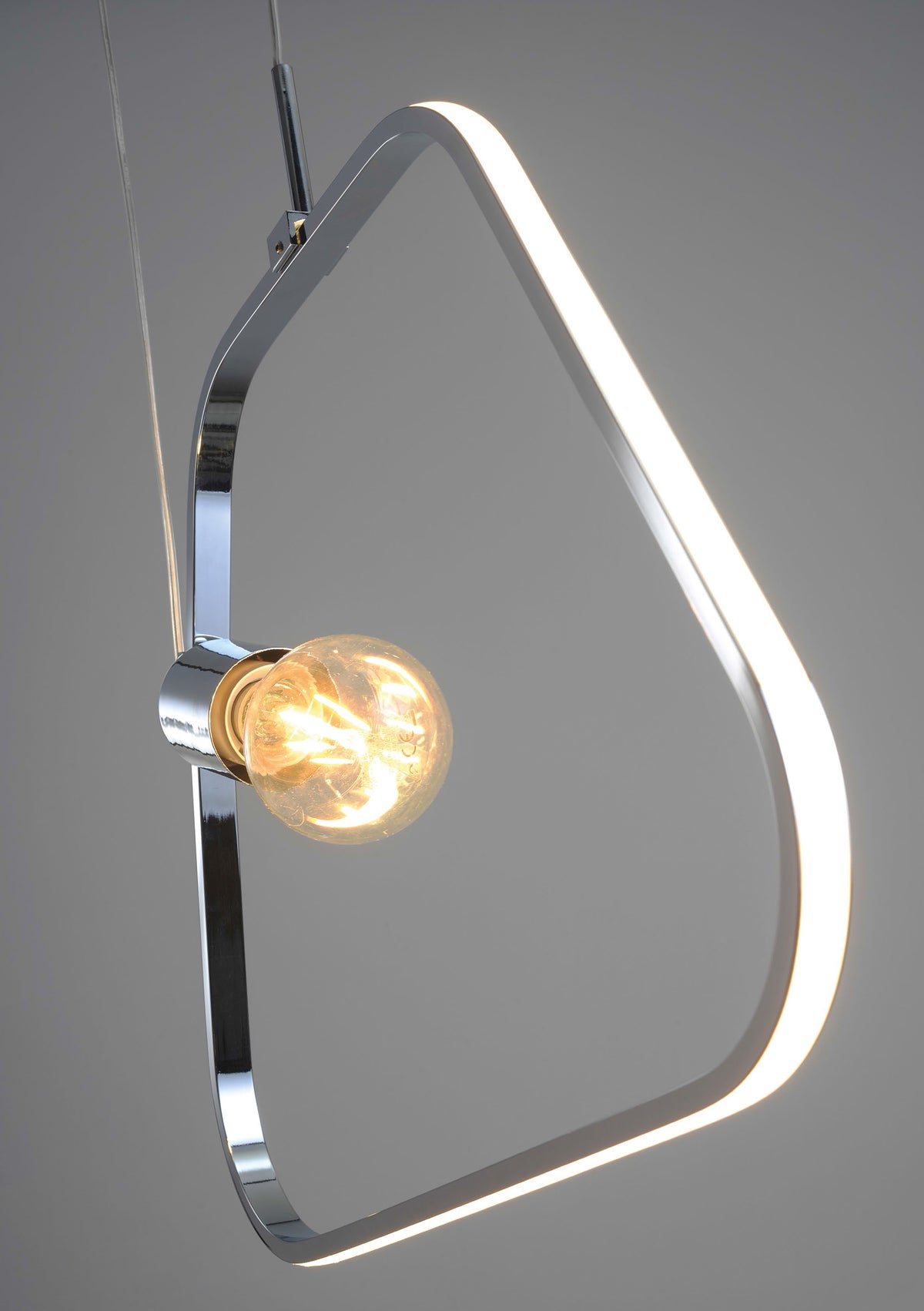 Détail du cadre chromé et de l'ampoule dorée allumée, finition brillante