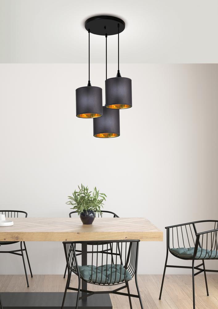Vue du luminaire suspendu au-dessus de la table, détails des trois cylindres noirs et dorés