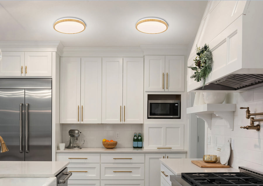 Vue large d'une cuisine blanche équipée, deux luminaires ronds éclairant la pièce