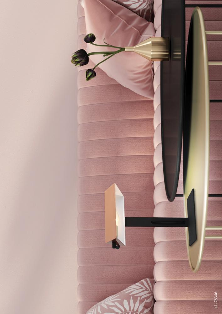 Vue de dessus, lampe noire et cuivrée sur table dorée devant canapé rose.